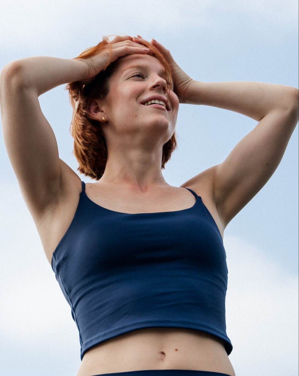 Woman in a blue athletic outfit against a light blue sky
