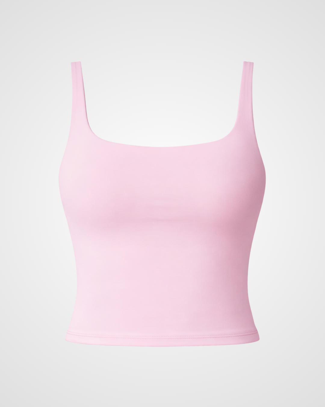 Powder pink square neck activewear tank laid flat with minimalist styling by Nuude
